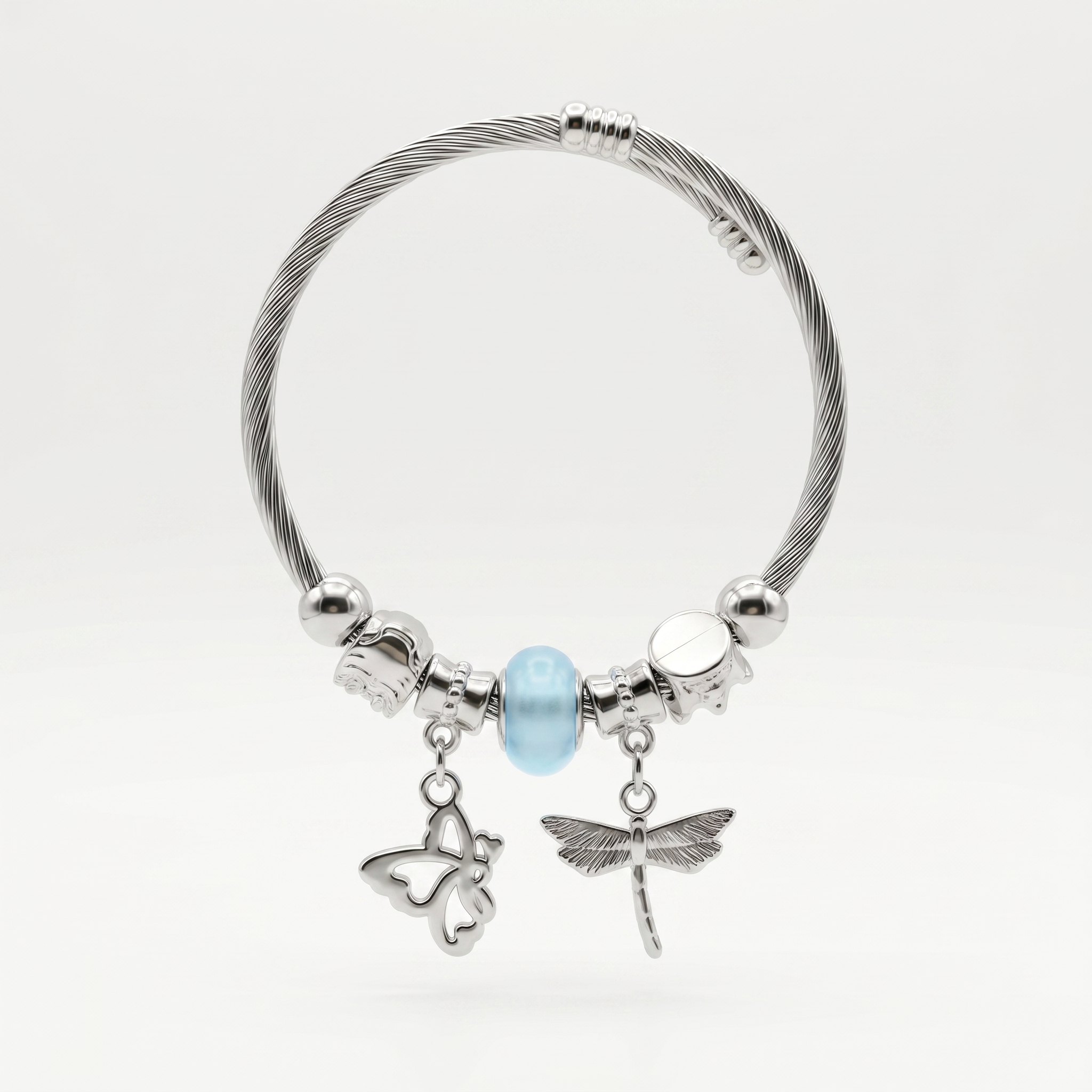 Silver bracelet with butterfly, dragonfly, and round charm on a white background