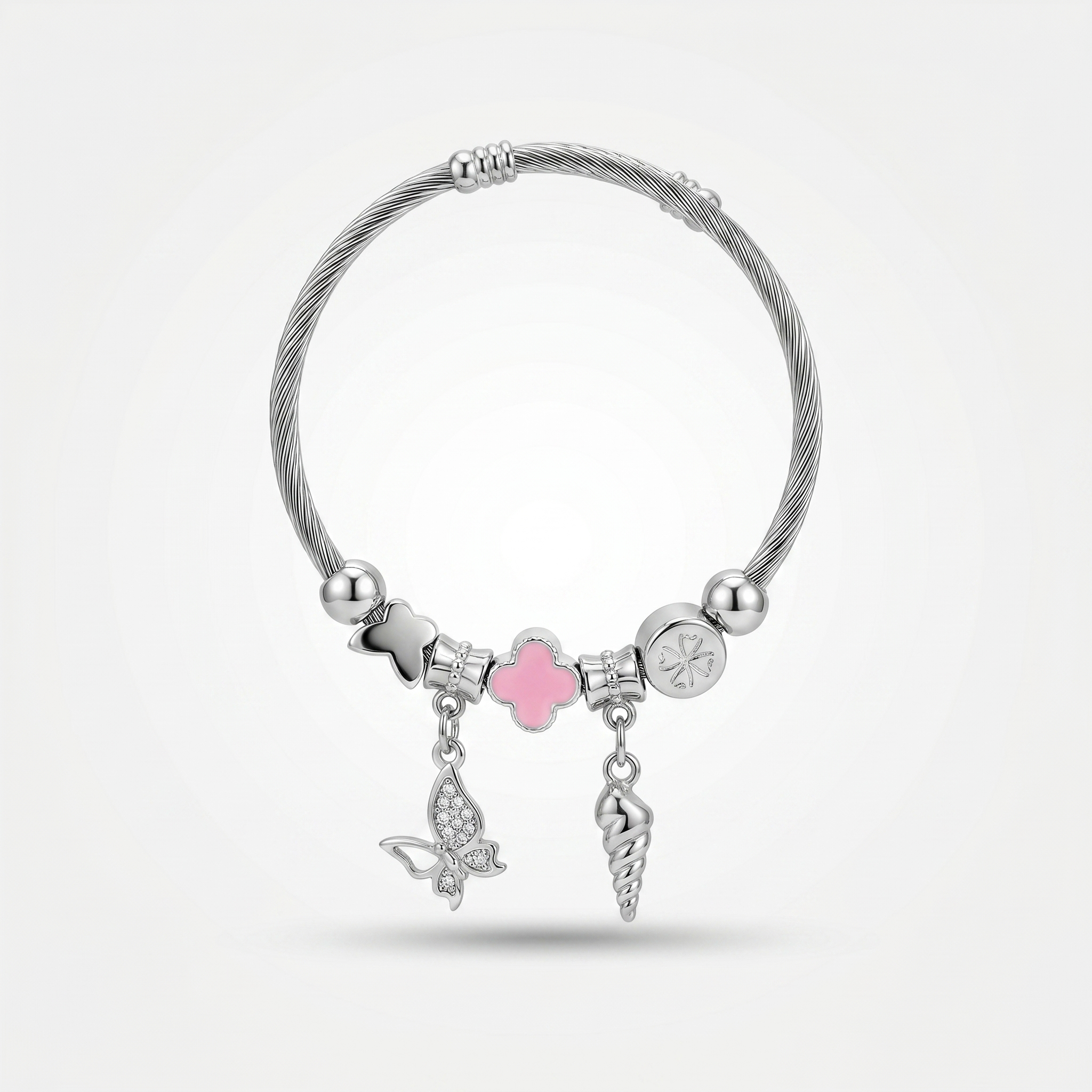 Silver bracelet with various charms including a pink heart, butterfly, and shell on a white background.